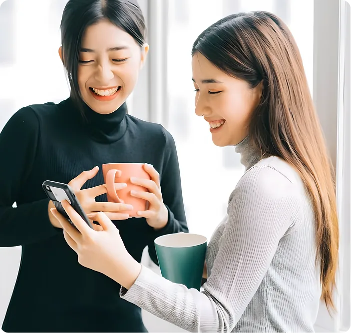 Two colleagues laughing over coffee